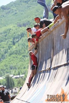 a group of young men riding down the side of a wooden ramp on top of a skateboard ramp