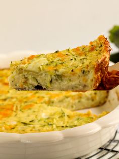 a piece of quiche being lifted from a casserole dish