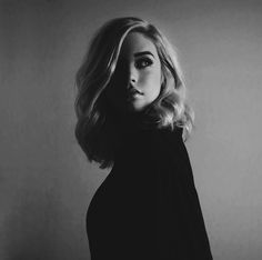 a black and white photo of a woman with blonde hair wearing a turtle neck sweater