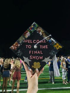 a person holding up a graduation cap that says welcome to the final show