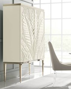 a white cabinet sitting next to a dining room table with chairs and a glass top table