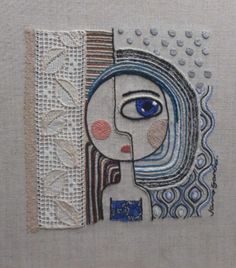 a close up of a piece of art on a cloth with beads and threads