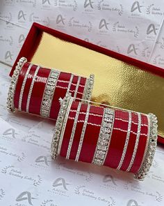 two red and white bracelets sitting in a box next to each other on top of a table