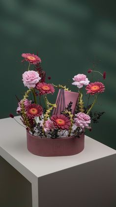 an arrangement of flowers in a pink vase