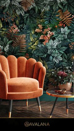 an orange chair sitting in front of a green wall with leaves and flowers on it