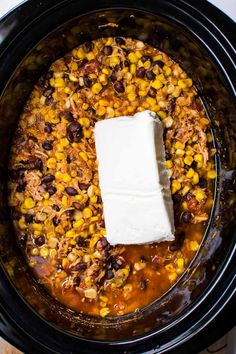 a crock pot filled with beans, corn and tofu