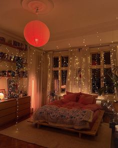 a living room filled with lots of furniture and christmas lights on the windows sill