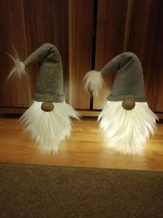 two gnome hats with white fur and brown buttons