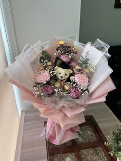 a bouquet of flowers with a teddy bear on it