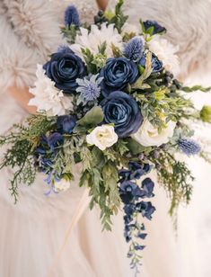 a bridal holding a bouquet of blue and white flowers