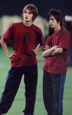 two young men standing next to each other with their arms crossed in front of them