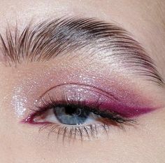 a woman's eye with pink and purple makeup