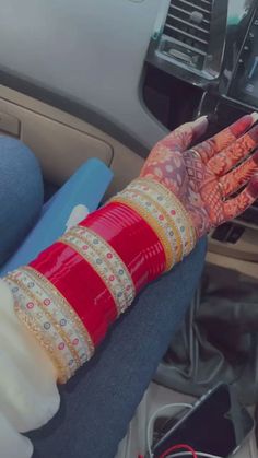 a woman with henna on her arm sitting in a car