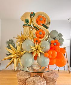 an arrangement of balloons and decorations on a table in a room with wood flooring