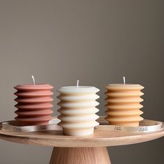 three candles sitting on top of a wooden tray