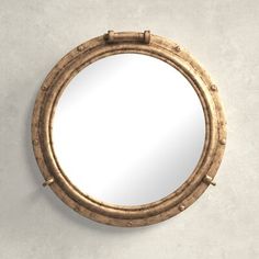 a round mirror hanging on the wall