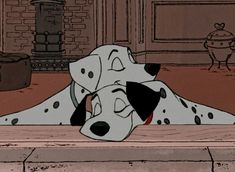 a dalmatian dog laying on the ground next to a fire place with its eyes closed