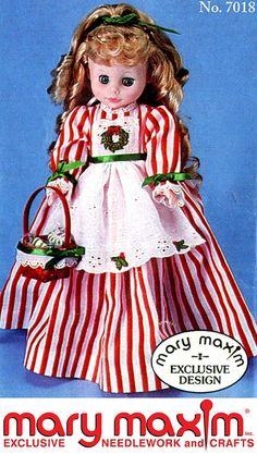 an old doll is wearing a red and white striped dress with green trimmings