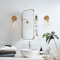 a bathroom sink with two lights above it and a mirror on the wall next to it