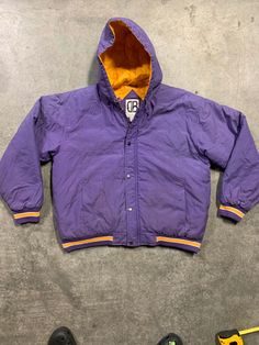 "90s 80s Hoodie Puffer Jacket.  This jacket has that Starter Jacket sporty vibe you would see in an old school Bell Biv Devo video.  It can also pass for a Lakers jacket. Stay warm and cool 😎 in this lovely 90s puffer.  It is a great jacket for your winter escapades.  Have fun in this puffy. The vintage item you are viewing is charmingly aged with time, therefore, minor wear should be expected and embraced.  The jacket has very light and minor blemishes and is in good vintage condition. Measure Streetwear Hooded Jacket With Fleece Lining, Retro Varsity Jacket For Sports Season, Hooded Outerwear For Streetwear During Sports Season, Urban Hooded Varsity Jacket For Sports Season, Casual Puffer Windbreaker For Streetwear, Throwback Winter Track Jacket For Sports, Retro Track Jacket For Winter College Wear, Retro Track Jacket For College In Winter, Retro Winter Track Jacket For College