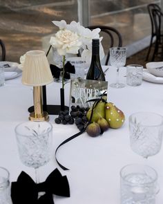 the table is set with wine, fruit and glasses for an elegant dinner or party