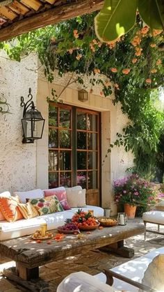 an outdoor living area with couches, tables and potted plants