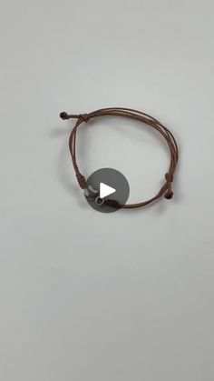 a brown cord bracelet with an arrow on it