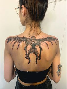 the back of a woman's upper body with tattoos on it