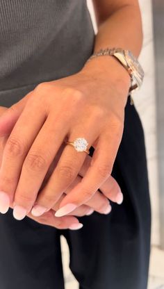 a woman's hand with a diamond ring on her left wrist and two other hands