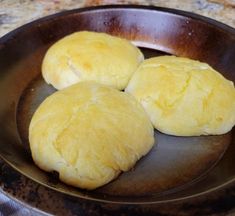 three round breads sitting in a pan on a counter top, ready to be cooked