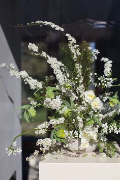 a vase filled with white flowers sitting on top of a table