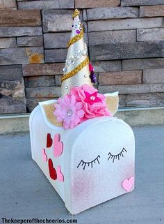 a white box with pink flowers and a unicorn's face painted on it