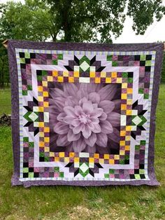 a large purple flower sitting on top of a lush green field