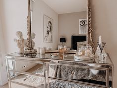 a large mirror sitting on top of a dresser in a living room next to a window