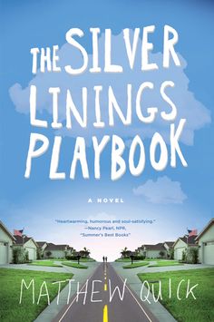 the silver linings play book is shown in front of an empty road and houses