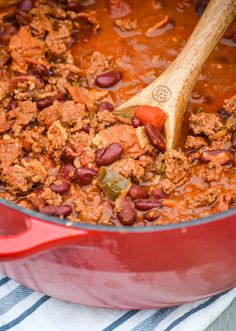 a red pot filled with chili and beans on top of a blue and white towel