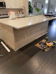 a kitchen with an island in the middle and tools on the floor next to it