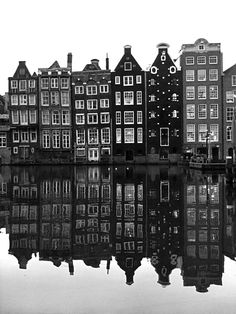 black and white photo of buildings reflecting in water