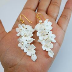 New to our Millennium Bride Collection These Beautiful Romantic WHITE FLOWER PETALS BRIDAL EARRINGS are made of very fine quality of beautifully made Ceramic flowers for your special day! Even we have hard time taking pictures because of their shine 😄 so we want to shine our brides on their special days. The material used in these earrings are free from Lead, Nickel, Cadmium so it will not give you any skin irritation and environment friendly too.. they measure about 7 inches long 3 inches wide White Flower-shaped Cluster Earrings For Anniversary, White Flower-shaped Cluster Earrings For Gifts, Handmade White Floral Bridal Earrings For Gift, White Flower Decorated Earrings For Anniversary, White Flower Earrings For Anniversary, Delicate White Flower Shaped Bridal Earrings, Delicate White Flower-shaped Bridal Earrings, White Drop Flower Earrings For Anniversary, White Cluster Flower-shaped Earrings