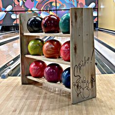 bowling balls are lined up in a wooden rack