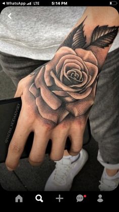 a man's hand with a rose tattoo on it