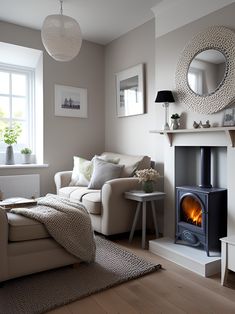 a living room filled with furniture and a fire place next to a window on top of a hard wood floor