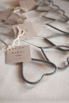 several tags are attached to strings on a white tablecloth with black cords and string