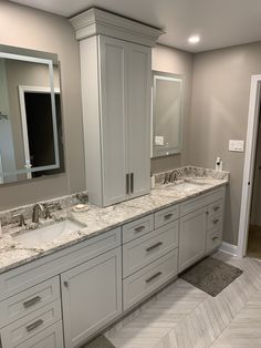 a bathroom with double sinks and two mirrors