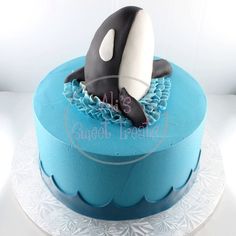 a blue cake with an orca whale on top