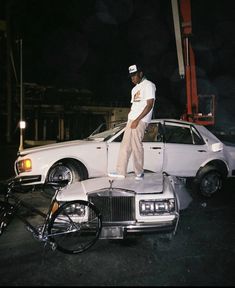 a man standing on top of a white car