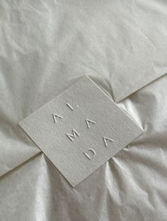 a piece of paper that is laying on top of a bed with the word now printed on it