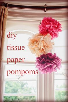 three tissue paper pompoms hanging from a window sill with the words diy tissue paper pompoms