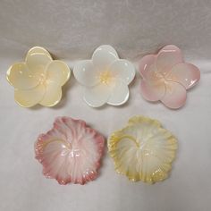 four flower shaped dishes sitting on top of a table