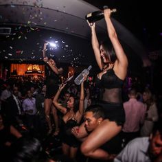 two women are dancing at a party with confetti thrown in the air above them